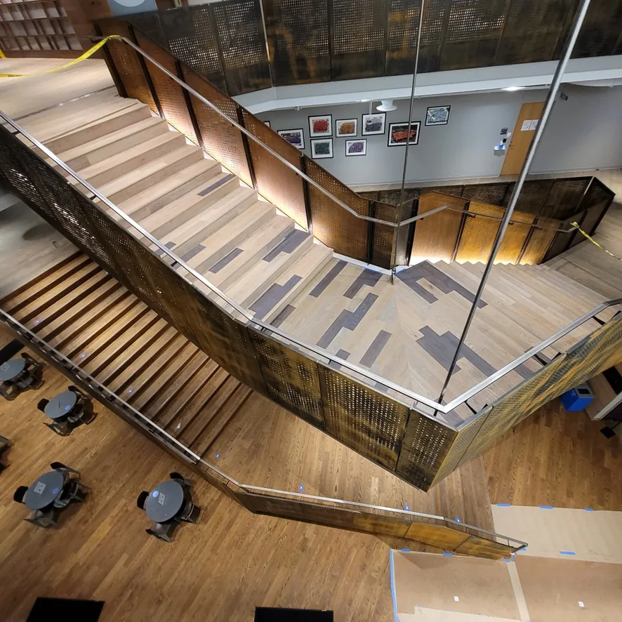 1 Wood Floors  Aerial view custom staircase landing with mixed-species wood pattern Ann Arbor Michigan. Installed by 1 Wood Floors, Livonia, MI