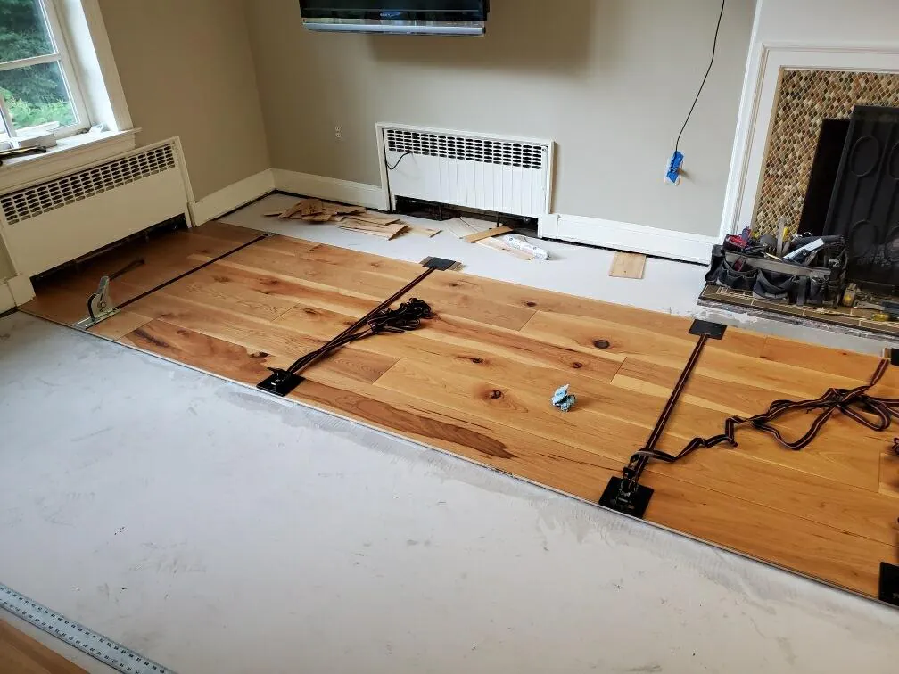 1 Wood Floors  Custom 8-inch wide plank hickory hardwood floor by Michigan Plank in the color Fireside, perfectly installed over a leveled concrete subfloor in Livonia, MI. Installed by 1 Wood Floors, Livonia, MI