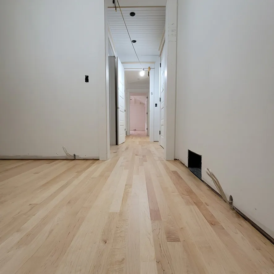 1 Wood Floors  Long hallway perspective showing invisible-finish maple flooring  Harbor Springs MI  Installed by 1 Wood Floors, Livonia, MI