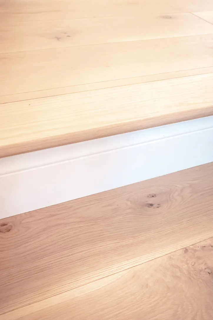 1 Wood Floors  Custom White Oak stair nosing and riser detail with color-matched 8-inch wide plank. Plymouth MI. Installed by 1 Wood Floors, Livonia, MI
