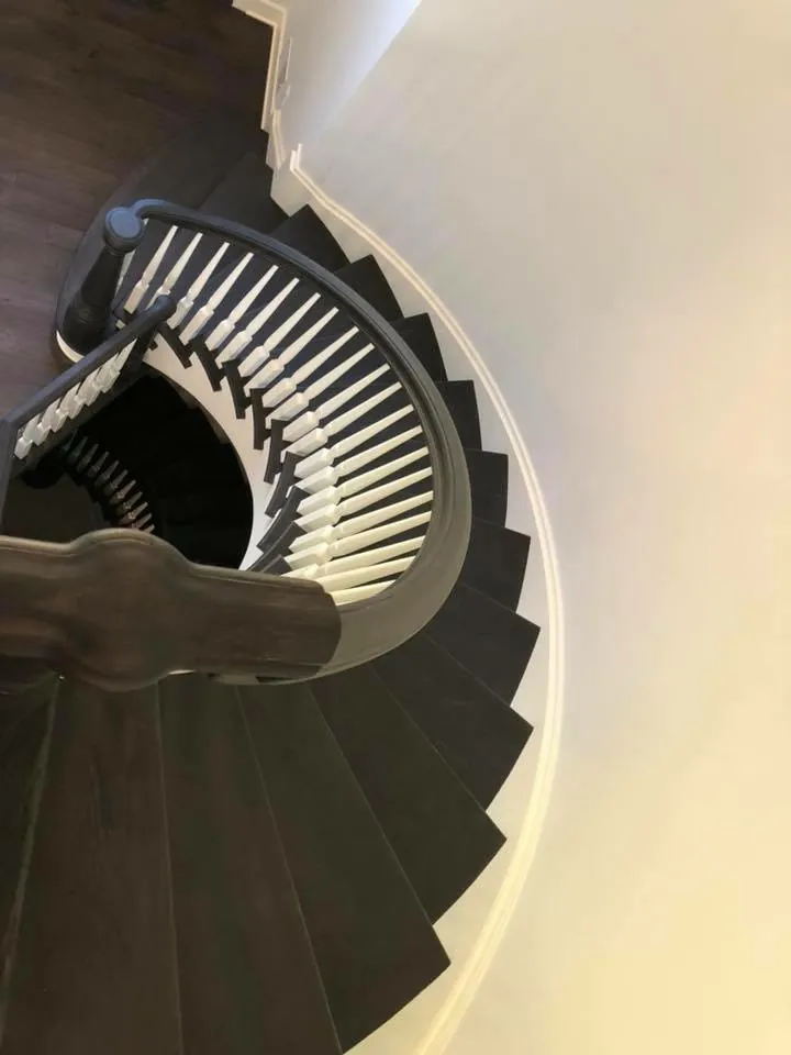 Straight-down spiral view showing dual staircases — Farmington Hills MI home with custom Red Oak and Dusky Walnut species integration throughout — 1 Wood Floors